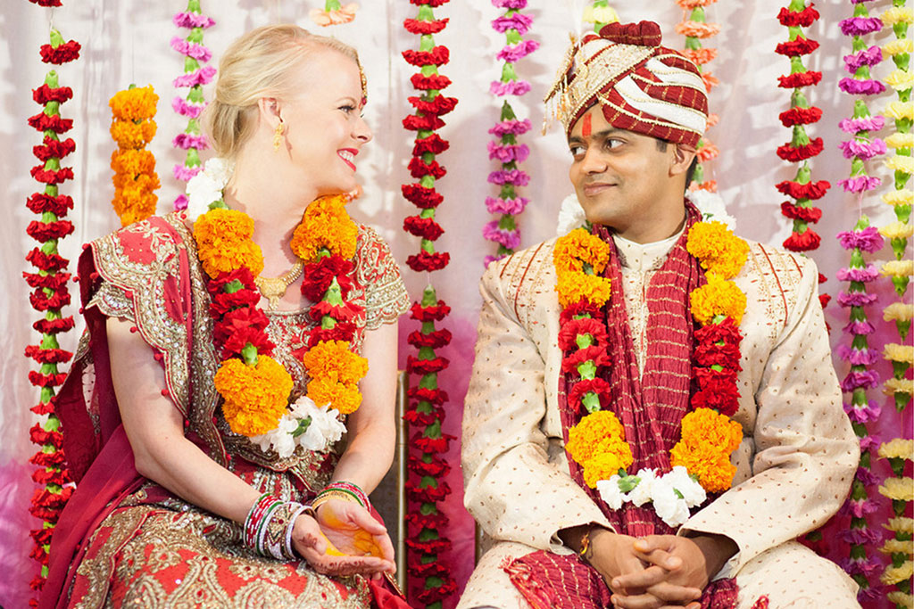 Bride and groom take an wedding day portrait in front colorful Indian Hindu mandap at Belo Mansion in Dallas