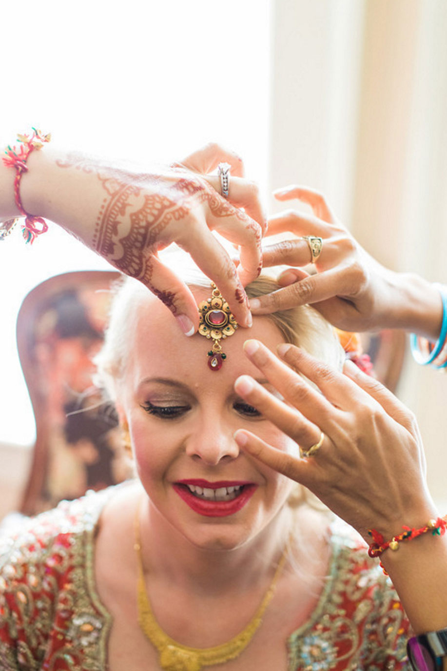 Bride getting Bindi forehead jewelry for Hindu wedding ceremony