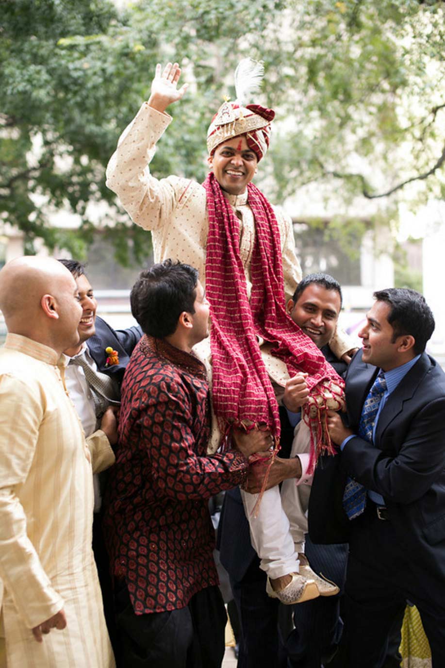 Indian wedding baraat, groom lifted on shoulders at procession at Belo Mansion in Dallas