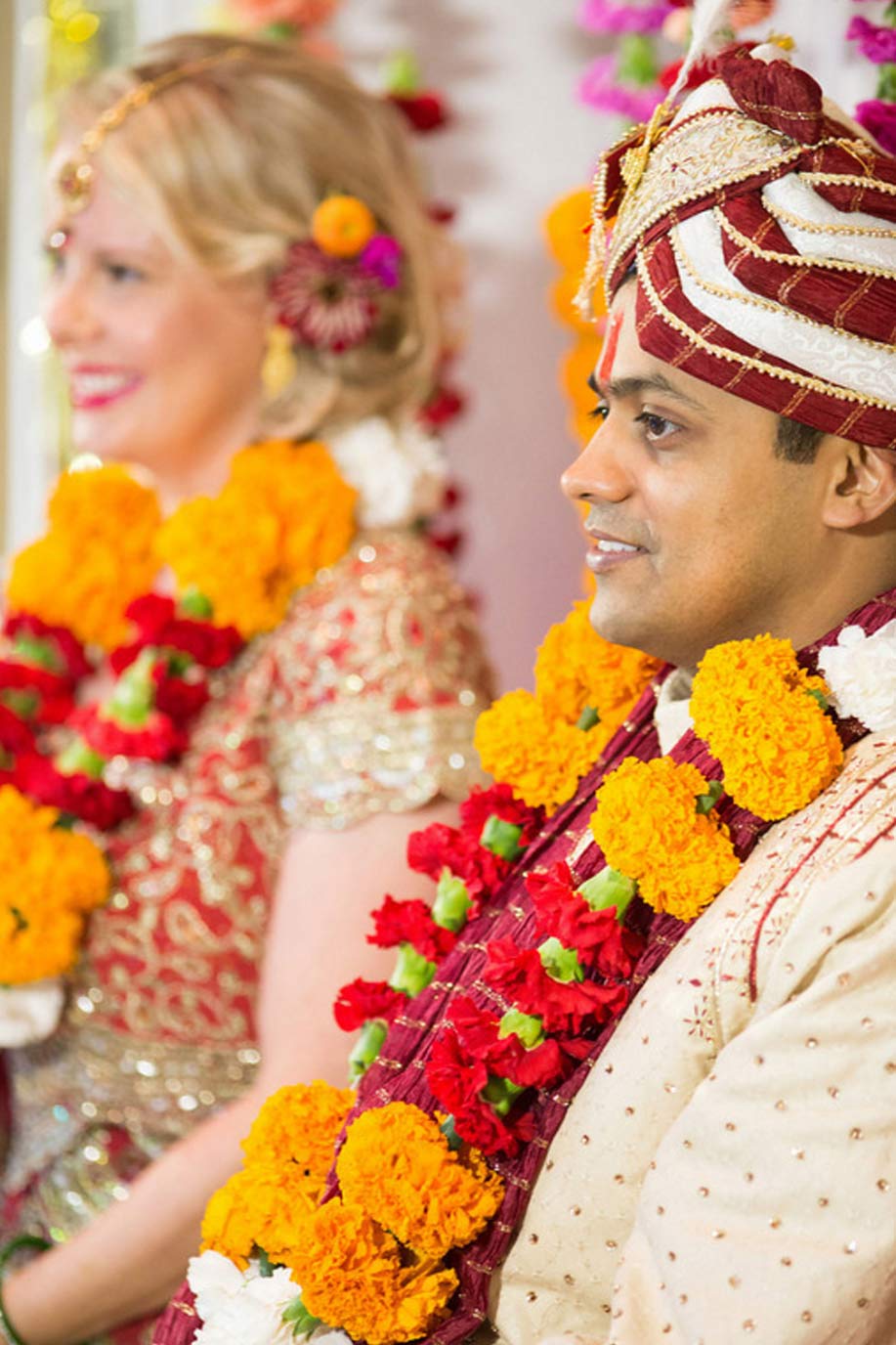 Bride and groom portrait in front of colorful Indian Hindu mandap