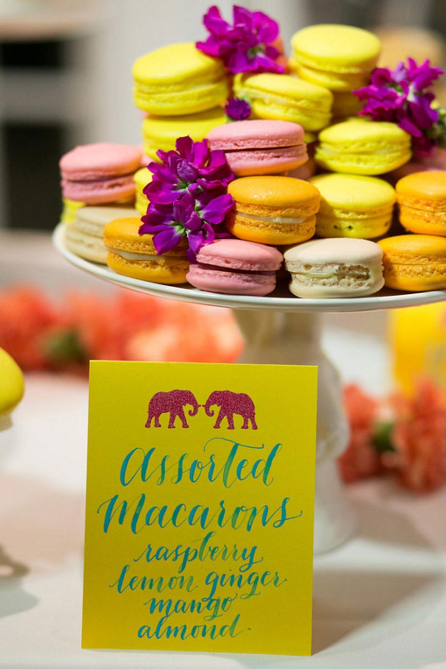 Colorful wedding macarons and yellow calligraphy place card with elephants