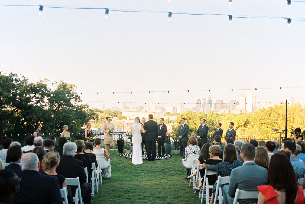 Wedding ceremony with cafe lights at The Belmont Hotel overlooking downtown Dallas