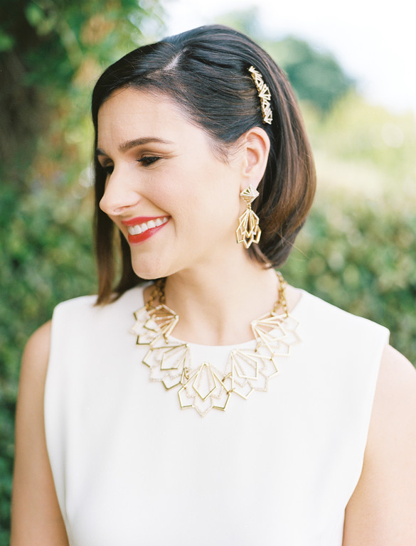 Wedding day bridal portrait featuring gold necklace, hair clip, and earrings
