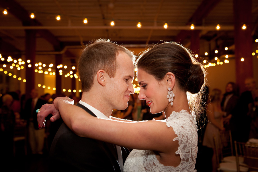 bride and groom first dance with cafe lights