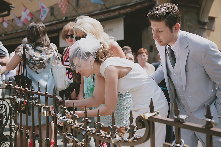 Bride and Groom Placing Padlock on Ponte Vecchio Gate