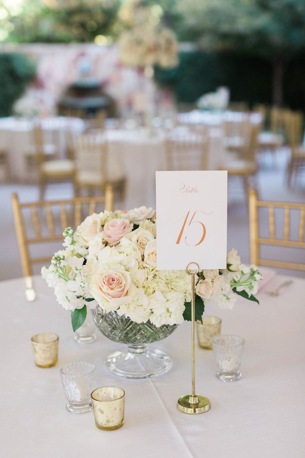 Low lush wedding centerpiece with gold calligraphy table number