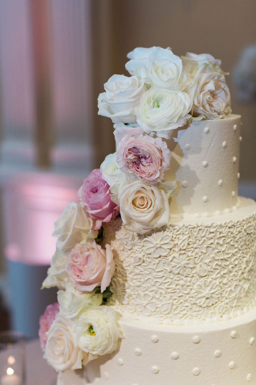 White wedding buttercream cake with blush and white blooms