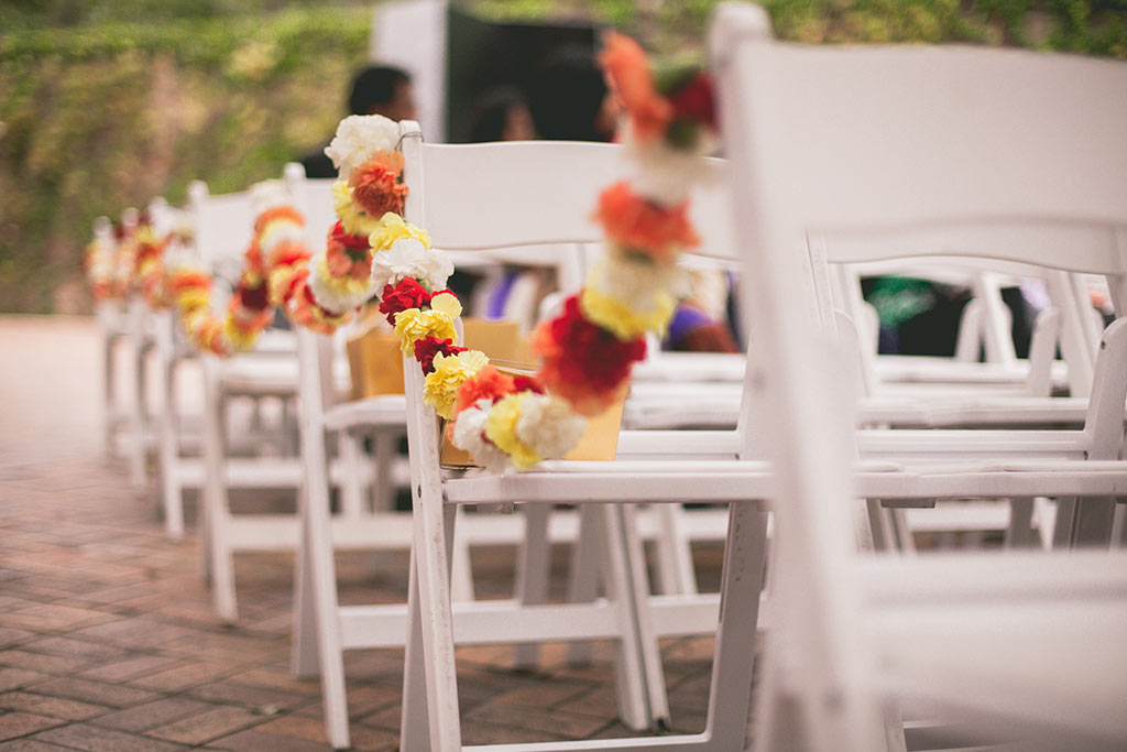 Carnation garlands on white garden chairs