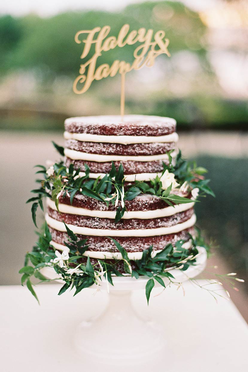 Naked wedding cake with floral greenery decor and gold laser cut topper