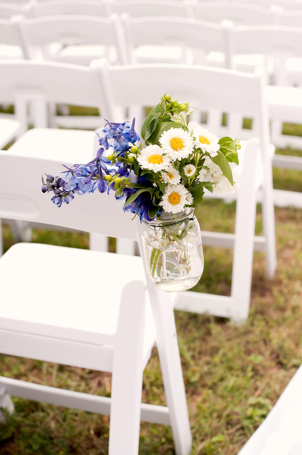 Texas Ranch Wedding white garden chairs and mason jar floral arrangement