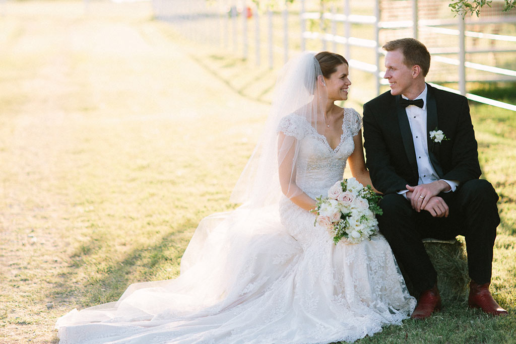 Bride and groom take a seated wedding day portrait at White Oaks Ranch in Texas