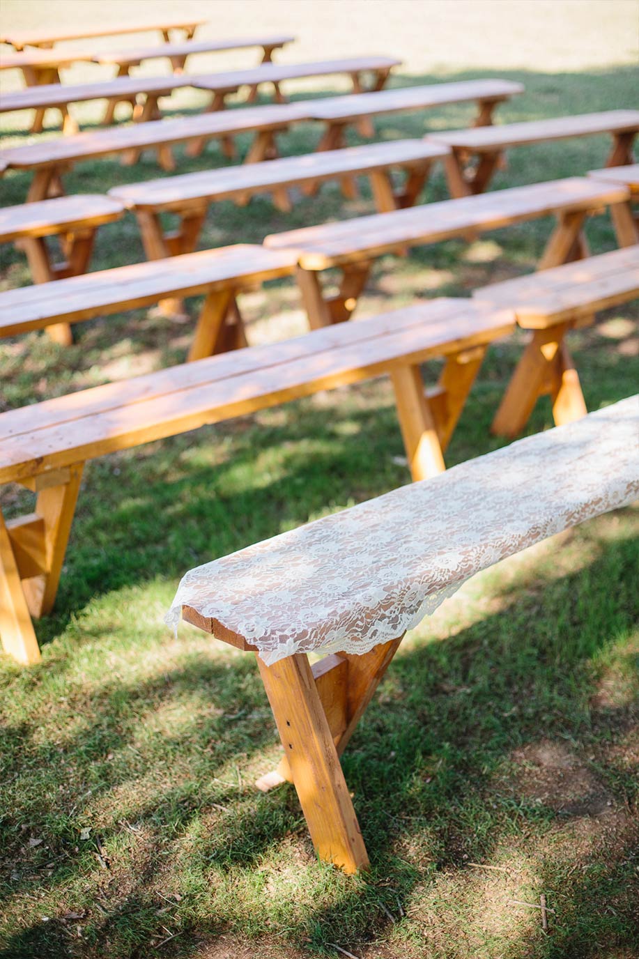 Outdoor wedding ceremony benches with lace toppers