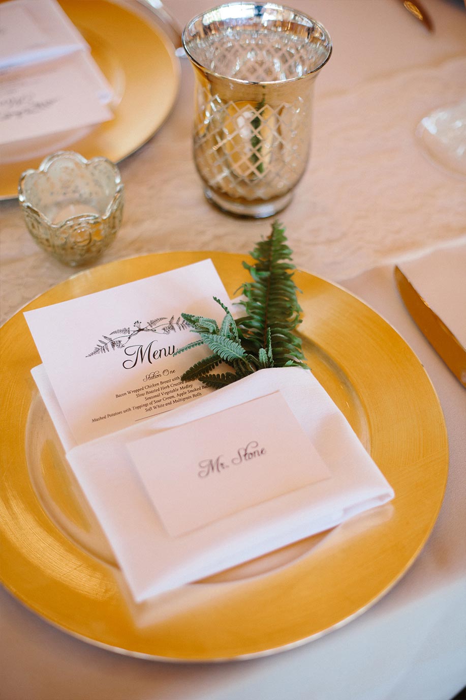 Menu card place setting with greenery, fern leaf, and yellow plate