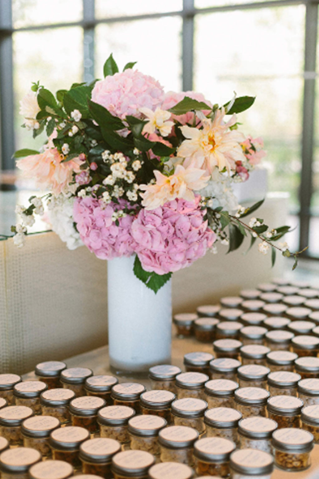Cookie jar wedding escort card setup with pink and peach floral