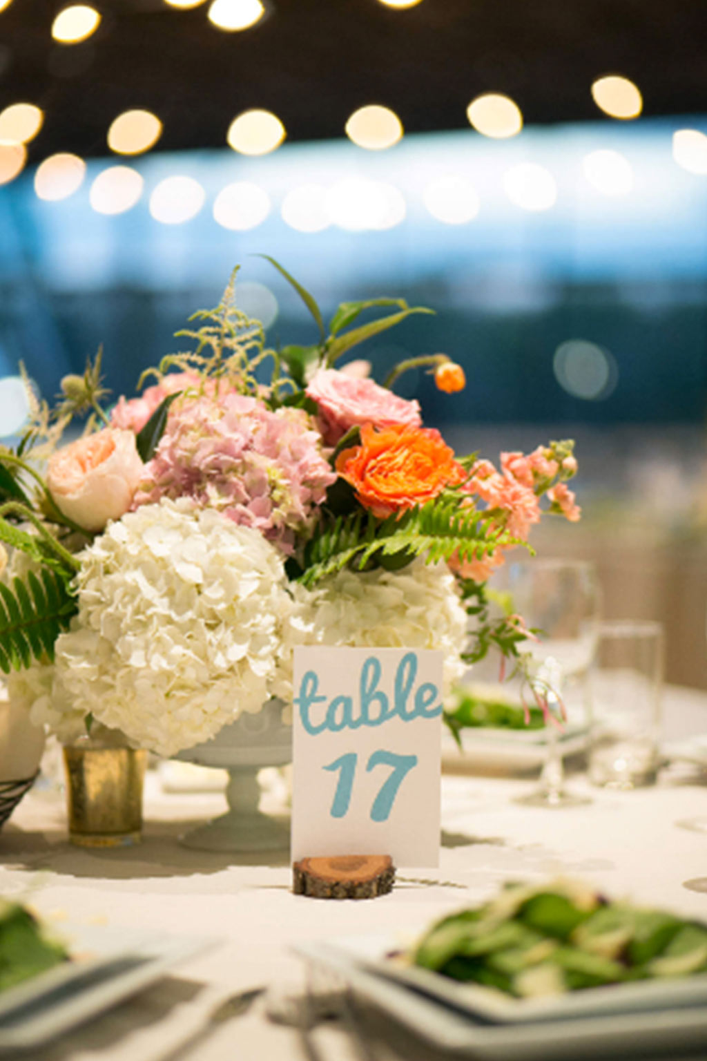 Blue calligraphy table number with low wedding centerpiece