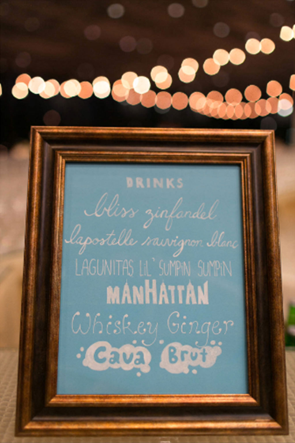 Blue hand lettered wedding cocktail sign