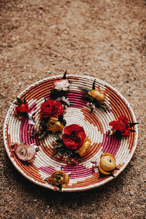 Ranunculus boutonnieres in a woven bowl for the groomsmen
