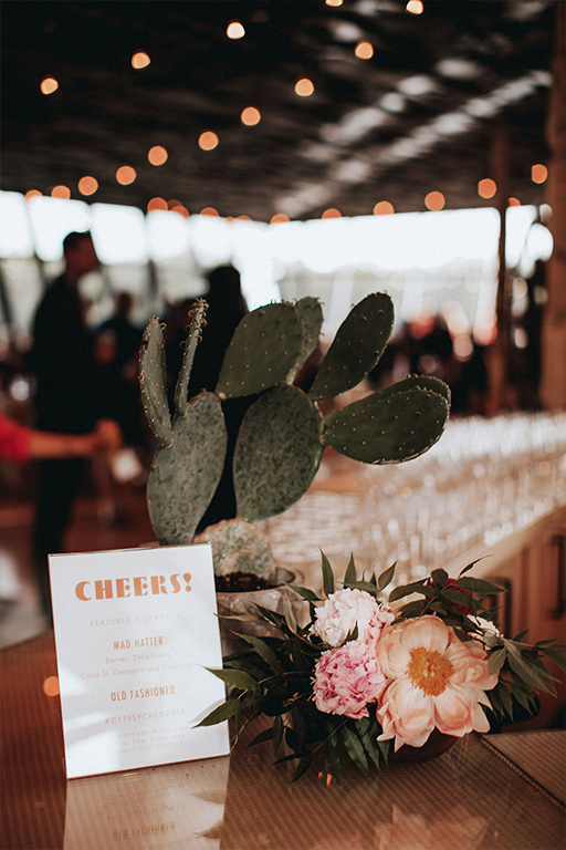 A bar sign drink menu with cactus at wedding reception