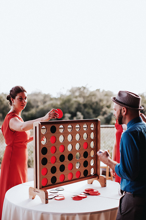 A giant wooden connect four game being played by wedding guests at the reception