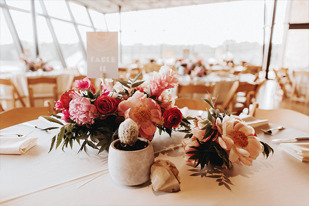 A collection of wedding reception centerpieces with geodes and concrete vessels at the Trinity River Audubon Center in Dallas