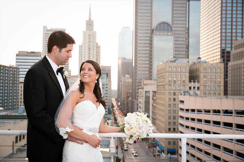 Bride and groom wedding day portrait overlooking downtown Dallas at The Room on Main