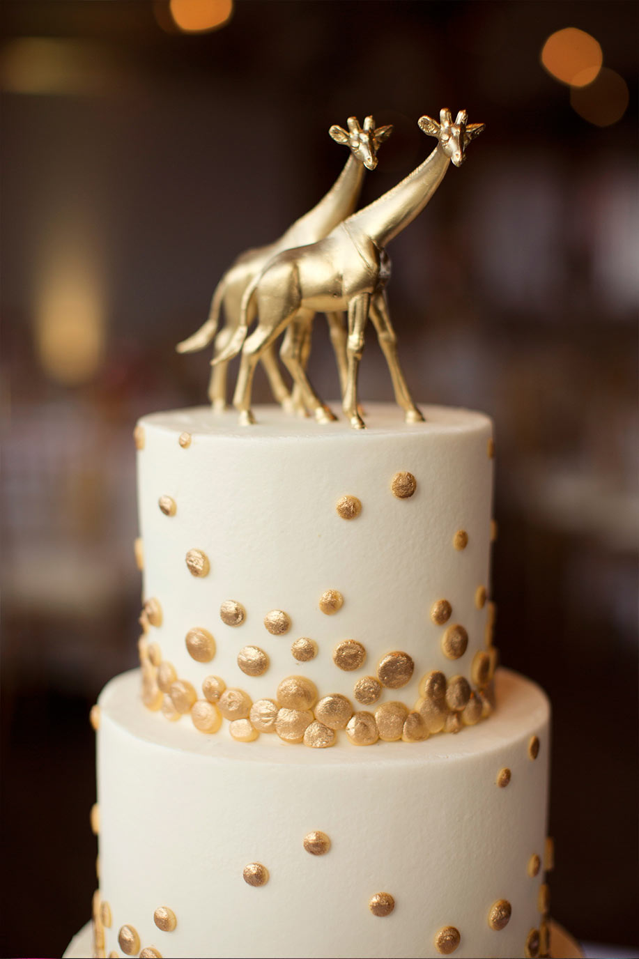 Brides wedding cake with gold polka dots and giraffe topper