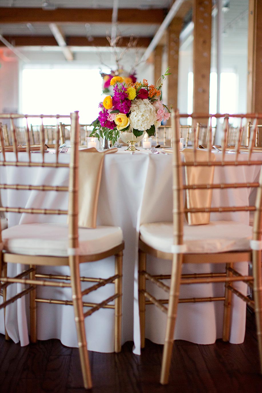 Bride and groom sweetheart table with gold chiavari chairs