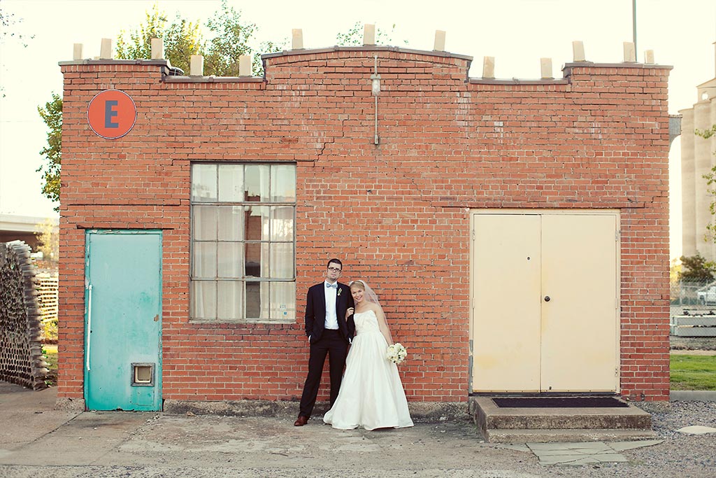 Bride and Groom wedding day portrait in front of brick industrial building at Hickory Street Annex in Dallas