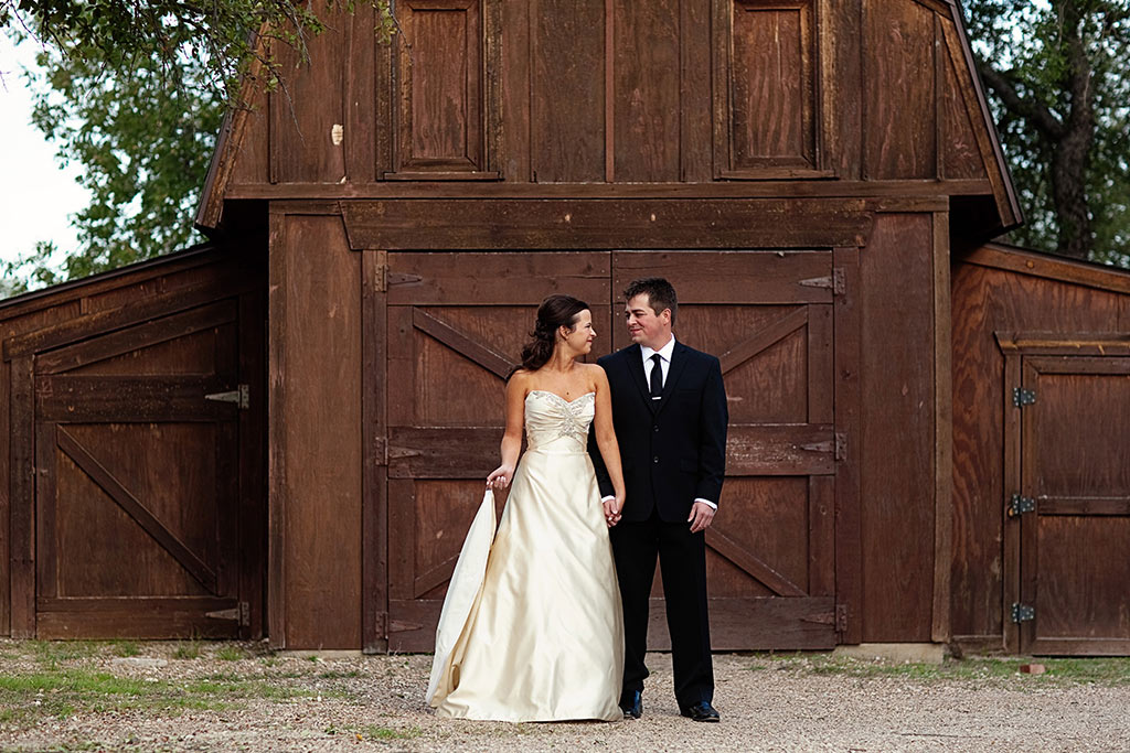 bride and groom portrait in front of barn