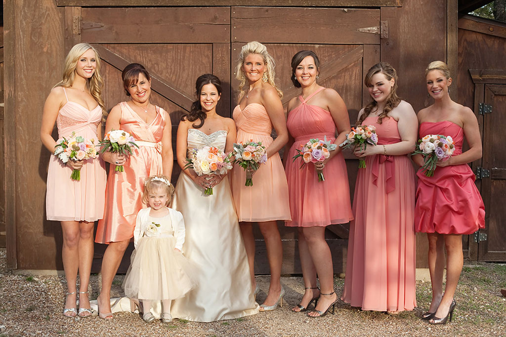 peach mix and match bridesmaids dresses in front of barn
