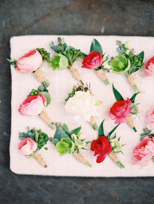 Pink and peach ranunculus wedding groomsmen boutonnieres with twine wraps