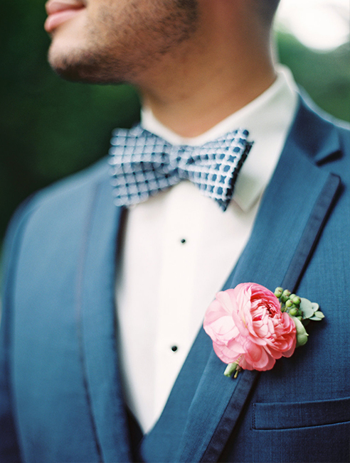 Navy wedding groomsman suit and bow tie with pink ranunculus boutonniere