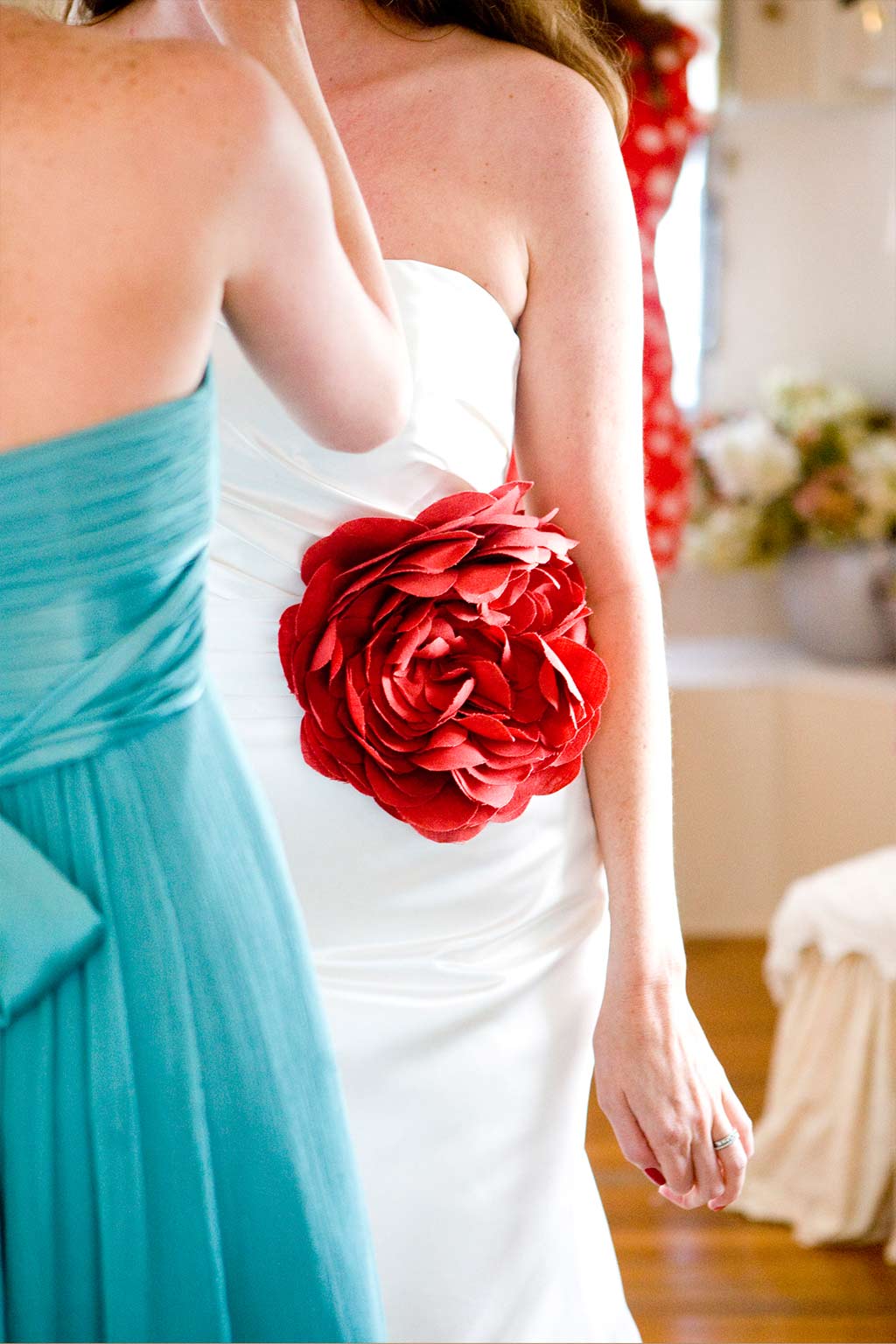 Bride getting ready with red floral pop of color