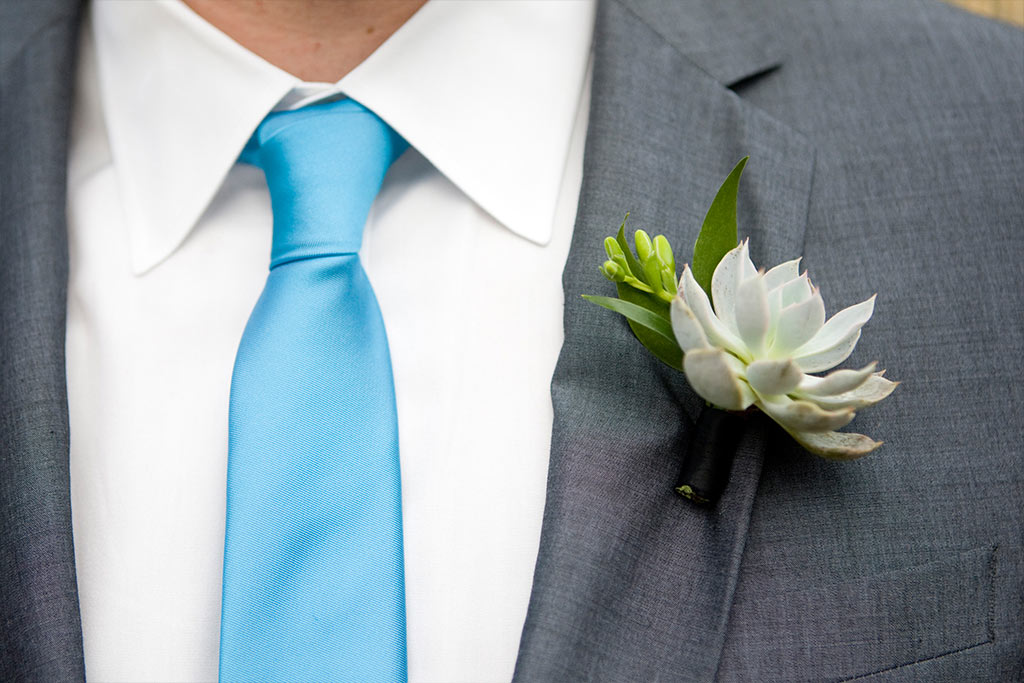 groom with succulent boutonniere, gray suit and blue tie