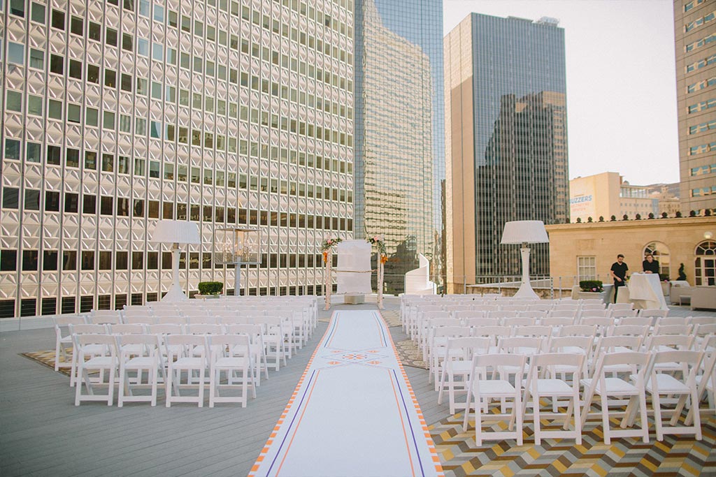 Wedding ceremony setup with custom aisle runner and chuppah on a downtown Dallas rooftop at The Venue at 400 North Ervay