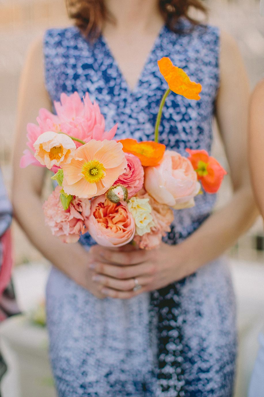 Bridesmaid with pink and orange bouquet and mix and match dress