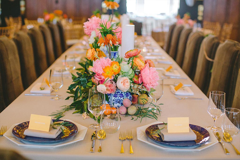 Wedding place settings with pink, orange, and blue details