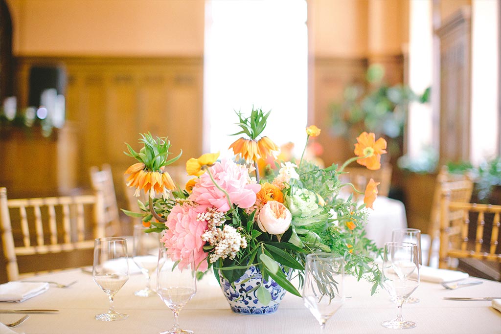 Pink and orange floral wedding centerpiece in blue and white porcelain vase