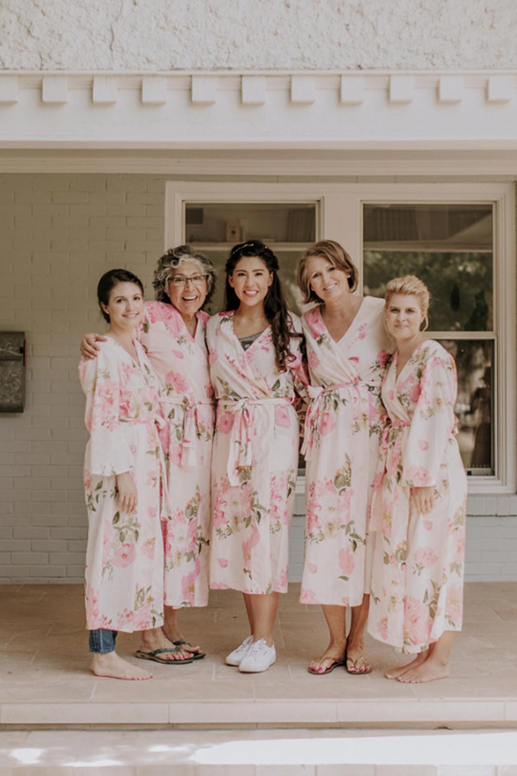 Bride and bridesmaids getting ready for wedding day with pink floral silk robes
