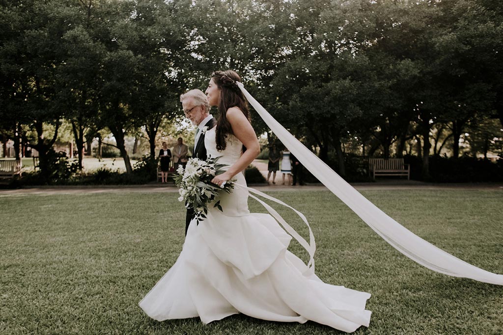 Father walking bride down the aisle with cathedral length long veil and Madison by Monique Lhuillier gown
