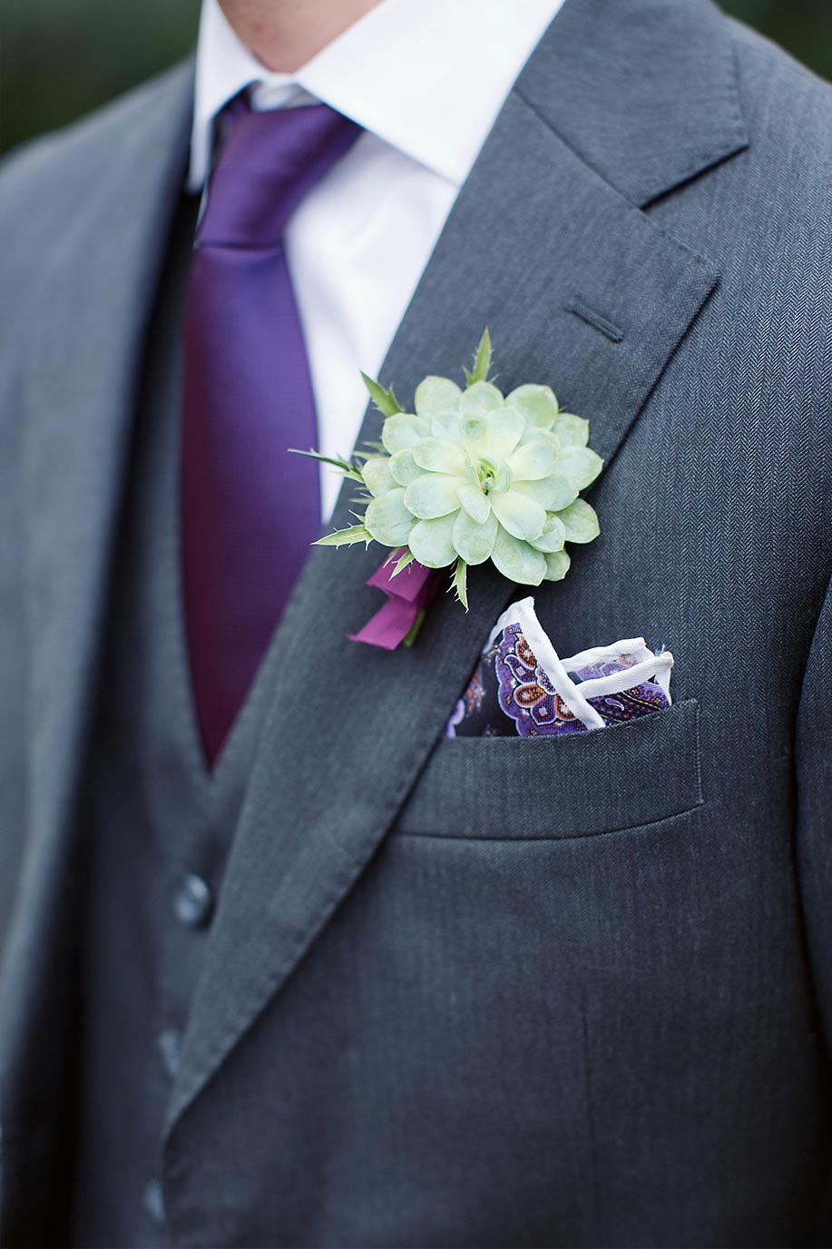 Groom's succulent boutonniere with purple tie and gray suit