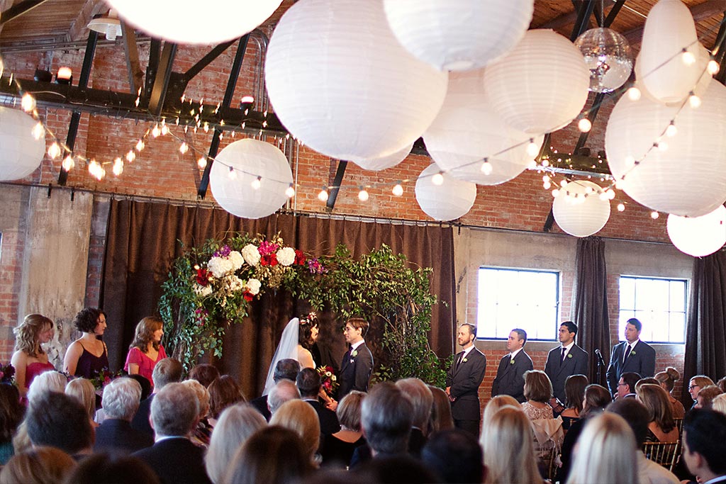 Wedding ceremony with floral and greenery altar at Hickory Street Annex in Dallas