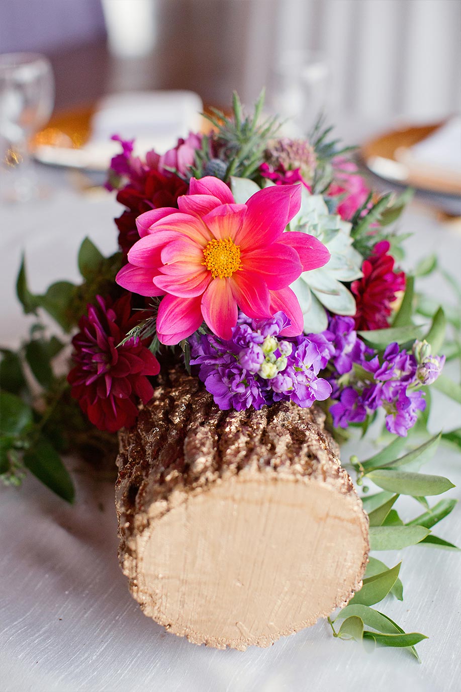 Gold log wedding centerpiece with pink and purple floral