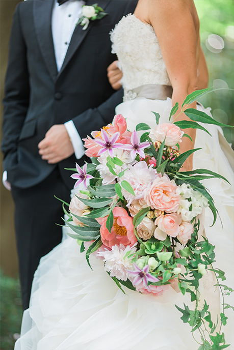 Groom and Bride portrait with cascading pink and peach bouquet