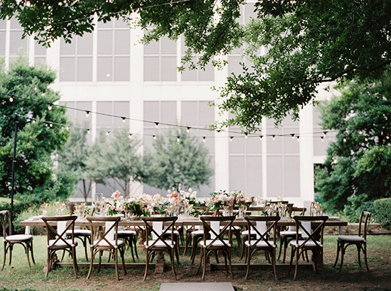 Wedding reception long table and cross back chairs with hanging cafe lights at Marie Gabrielle in Dallas