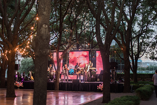 Emerald City Band on stage with outdoor dance floor and cafe lights at wedding reception at Marie Gabrielle in Dallas